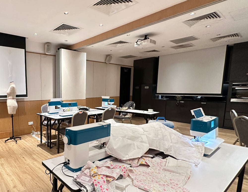 Classroom with PFAFF® ambition™ 620 sewing machine, mannequin, and screens.